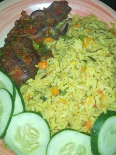 A picture of Fried rice with peppered chicken dressed with cucumber.