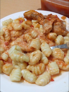 Una foto de Ñoquis de papa acompañado de salsa de tomate con pollo