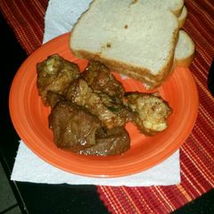 A picture of Pan fried pork and beef heart with bread.