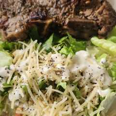 Una foto de T Bone con ensalada Caesar