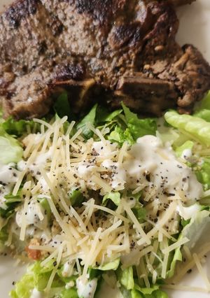 Una foto de T Bone con ensalada Caesar