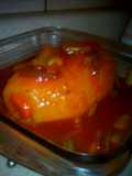 Papa rellena bañada en salsa de tomate con cebolla cambray