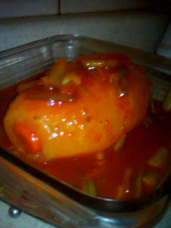 Una foto de Papa rellena bañada en salsa de tomate con cebolla cambray