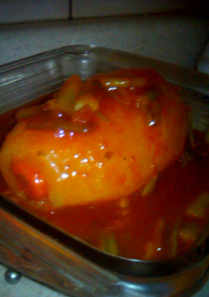 Una foto de Papa rellena bañada en salsa de tomate con cebolla cambray