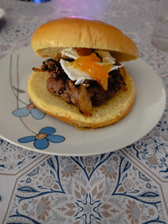Una foto de Hamburguesa de vaca con queso de cabra, cebolla caramelizada y mermelada