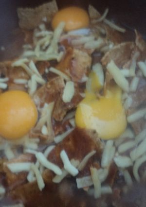 Una foto de Chilaquiles de chile cascabel con pulque y huevos Martín