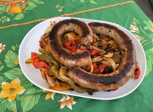 Une photo de Saucisse au couteau aux poivrons tricolores, tomates et oignon marinés