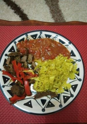A picture of Stir fry steak with steamed cabbage and sauce.