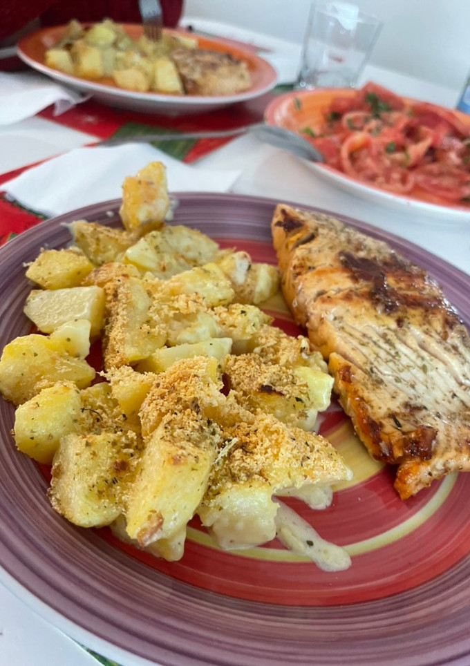 Una foto de Papas gratinadas con queso y crema, acompañadas de salmón a la plancha