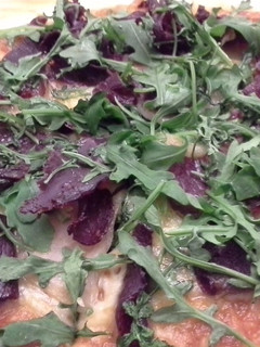 Una foto de Pizza de cecina y rúcula