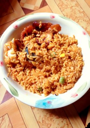A picture of Jollof rice with fried plantain and fish.