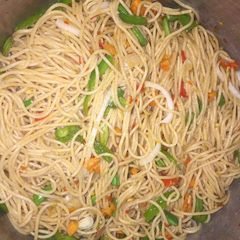 A picture of Spagetti with green pepper and carrots.