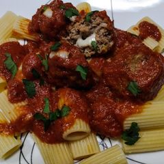 A picture of Mozzarella stuffed meatballs in tomato sauce.