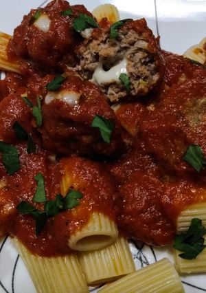 A picture of Mozzarella stuffed meatballs in tomato sauce.