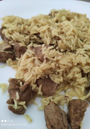 Una foto de Arroz basmati con cordero al curry, hierbas y un toque de limón