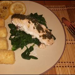 A picture of Simple citrus salmon on a bed of spinach w/ potatoes.