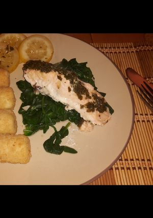 A picture of Simple citrus salmon on a bed of spinach w/ potatoes.