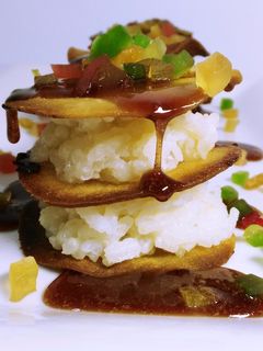 Una foto de Milhoja dulce de pan rústico con arroz con leche, frutas confitadas y sirope de frutos rojos