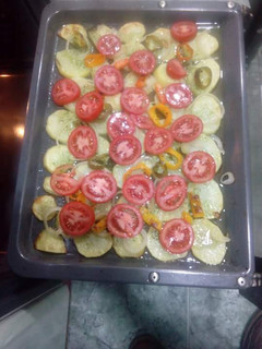 Una foto de Patatas asadas al horno con tomates y cebolla