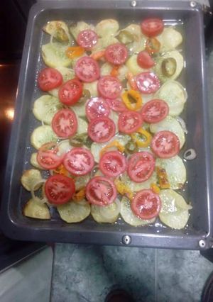 Una foto de Patatas asadas al horno con tomates y cebolla