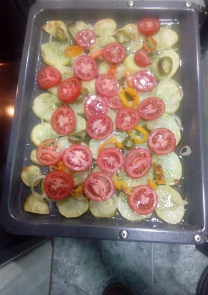 Una foto de Patatas asadas al horno con tomates y cebolla