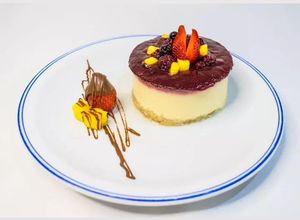 Una foto de Cheesecake de mango, con salsa de frambuesa y arándanos 🥭
