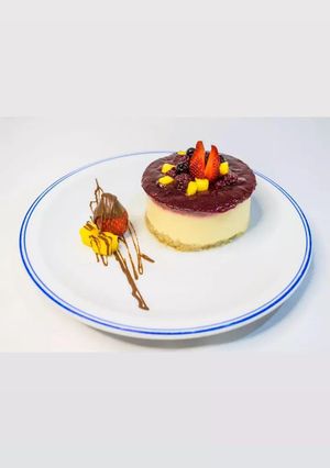 Una foto de Cheesecake de mango, con salsa de frambuesa y arándanos 🥭