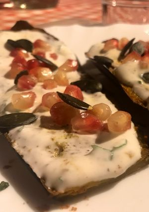 Une photo de Aubergines Grillé au cumin feta grenade et sauce au yaourt