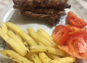 Una foto de Pechito de cerdo con manta y papas al horno