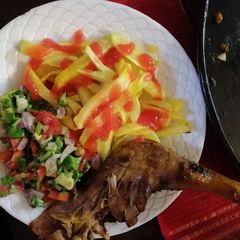 A picture of Roasted kienyenji chicken served chips and kachumbari.