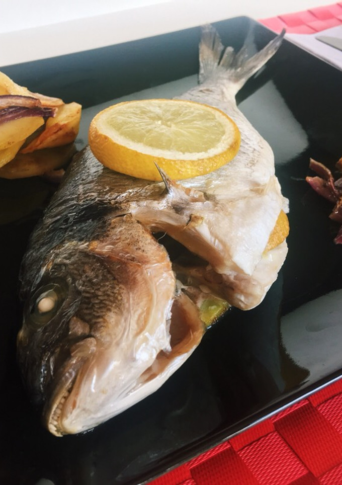 Una foto de Dorada al horno con patatas