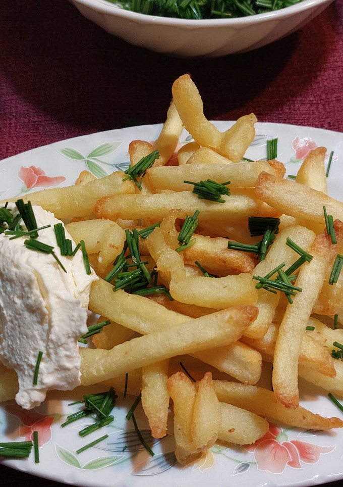 Una foto de Papas fritas con queso crema casero y ciboulette 🤤🤤