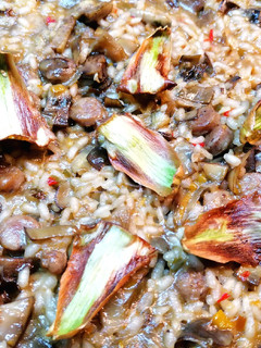 Una foto de Paella con salchichas del país y crujiente de alcachofas