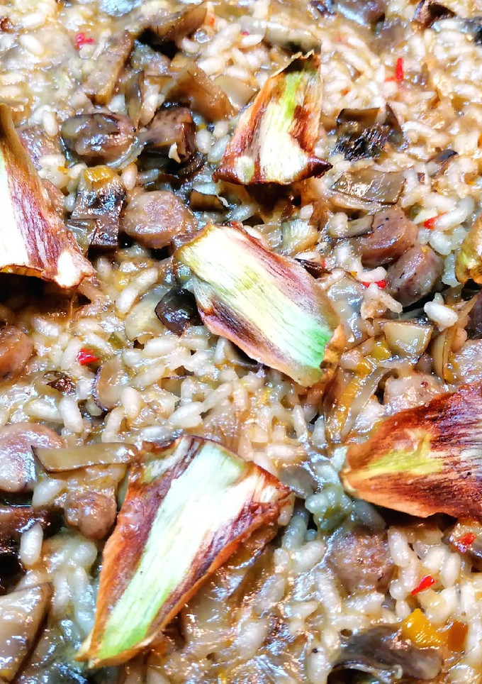Una foto de Paella con salchichas del país y crujiente de alcachofas