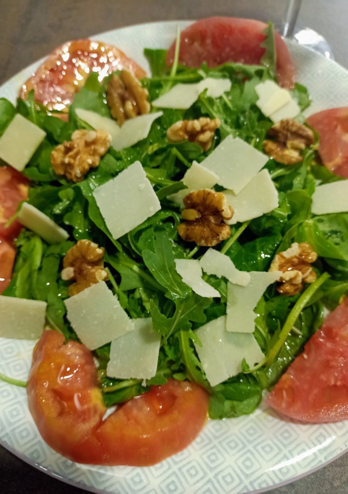 Una foto de Ensalada de tomate rosa, rúcula, Grana Padano y nueces