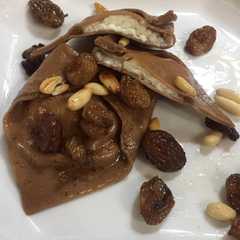 A picture of Tortelloni al cacao ripieno ricotta e pere su uvetta e pinoli.