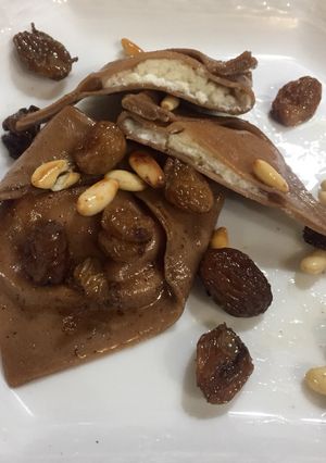 Foto di Tortelloni al cacao ripieno ricotta e pere su uvetta e pinoli