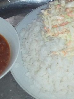 A picture of White rice, salad and tomatoes stew.