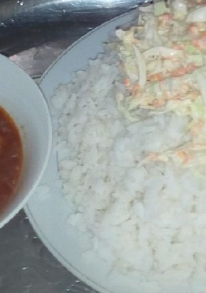 A picture of White rice, salad and tomatoes stew.