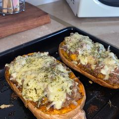A picture of Butternut filled with minced meat topped with mozzarella cheese.