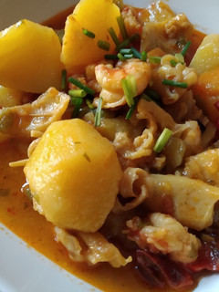 Una foto de Patatas guisadas con sepia y gambas