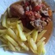 Muslos de pollo con setas acompañado con patatas fritas