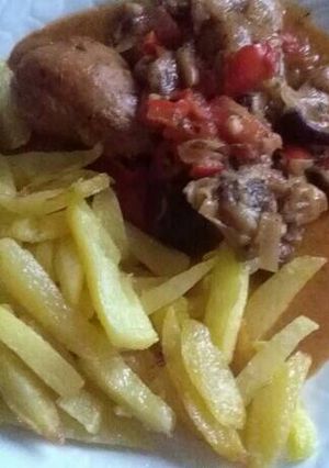 Foto principal de Muslos de pollo con setas acompañado con patatas fritas