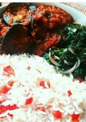 A picture of White rice with snail Stew and steamed spinach.