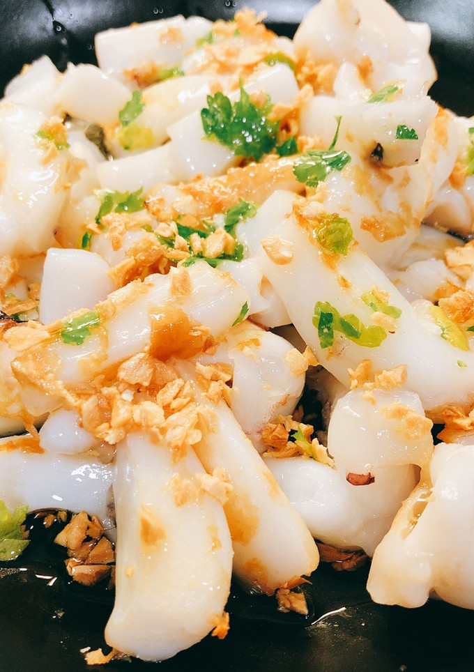 Una foto de Sepia al ajillo con ajo crujiente y pimientos de Padrón