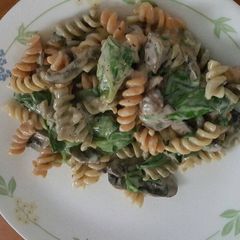 A picture of Mushroom spinach pasta with alfredo sauce.