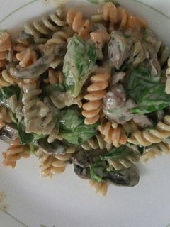 A picture of Mushroom spinach pasta with alfredo sauce.
