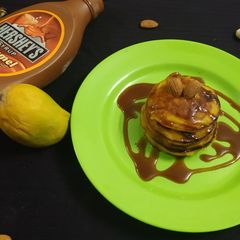 A picture of Mango Pancakes with Almonds and Caremal Sauce.