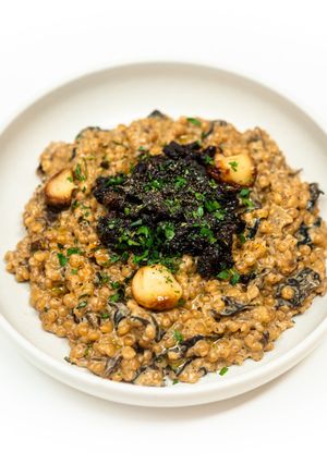 A picture of Creamy Pearl Couscous with Wild Mushrooms and Wine-Braised Sun-Dried Tomatoes.