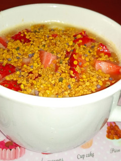 Una foto de Zumo de naranja con plátano, fresas y polen de flores